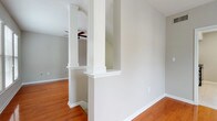 Located in Atlanta's prestigious 30327 zip code, this two-story residence offers a thoughtfully designed layout with a variety of finishes throughout. The main level features a combination of tile and hardwood flooring, with the living area defined by elegant decorative columns with detailed molding that create a natural separation of spaces. Ceiling fans are present throughout, contributing to comfort across both floors.

The kitchen is well-equipped with white shaker-style cabinetry, granite countertops, a subway tile backsplash, and a full suite of stainless steel appliances, including a range, microwave, and dishwasher. Tile flooring carries through this functional space.

A hallway on the main level connects key areas through an arched passageway, lending architectural charm. A half bathroom with wood-look flooring provides convenience on this floor, alongside a dedicated laundry area with tile flooring and a window for natural light.

The upper level hosts multiple carpeted bedrooms, each featuring neutral tones, ceiling fans, and windows with blinds that invite natural light. The primary bedroom connects directly to a private bathroom outfitted with a granite-topped vanity, wood-look flooring, and a bathtub. Additional bedrooms share access to a full bathroom with similar finishes.