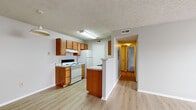 This 2-bedroom, 2-bathroom single-floor home at 833 Misty Hallow Ln. in Columbus, Ohio offers a practical and comfortable layout with a clean, neutral aesthetic throughout. The combined kitchen and living area forms the heart of the home, featuring warm wood-toned cabinetry, light marble-style countertops, white appliances including an electric range and refrigerator, and light wood-style flooring that extends through the main living spaces. A peninsula-style counter divides the kitchen from the adjoining area, creating an open flow. A central hallway connects the main living area to the two bedrooms, each featuring neutral carpet flooring, textured ceilings, and windows that bring in natural light with outdoor views. The primary bedroom includes a built-in closet, while the second bedroom also features a dedicated closet with bifold doors and a pendant light fixture. Three total closets provide generous storage throughout. Both bathrooms are finished with wood-toned vanities, white countertops, and light wood-style flooring. One bathroom includes a walk-in shower, while the other offers a full shower-tub combo. The space presents a functional and well-organized floor plan well-suited for everyday living.