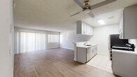 Located at 6000 Buckingham Parkway in Culver City, California, this single-story one-bedroom residence offers a well-organized and efficiently designed layout. Light wood-tone flooring flows throughout the main living areas, complemented by crisp white walls and textured ceilings, creating a clean and airy atmosphere.

The open-concept living room is generously sized, bathed in natural light streaming through large vertical-blind-covered windows and a sliding glass door that opens to the exterior. A ceiling fan adds comfort to the space. The kitchen is neatly appointed with white cabinetry, white countertops, stainless steel appliances including a refrigerator and electric range, and a built-in dishwasher. A skylight overhead brightens the kitchen with natural light, while tile flooring provides a practical and polished finish.

The spacious primary bedroom is one of the standout features of this residence, offering ample room and a window for natural light. It includes mirrored sliding closet doors that open to a well-shelved storage area, enhancing both functionality and the sense of space. A hallway connects the main living areas to the bedroom and bathroom, providing a logical and private flow throughout the unit. Overall, the space presents a bright, neutral, and move-in-ready environment in a prime Culver City location.