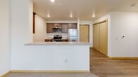 Located at 810 Seventh Ave NE in Isanti, Minnesota, this single-floor 2-bedroom, 2-bathroom residence offers a well-organized layout designed for comfortable everyday living. The open-concept kitchen and living area serves as the heart of the unit, where the kitchen is outfitted with rich dark cabinetry, granite-style countertops, a stainless steel refrigerator, range, built-in microwave, and dishwasher, all set atop light hardwood-style flooring. A peninsula counter defines the transition into the carpeted living area, which features a ceiling fan with lighting and access to a private outdoor deck overlooking open green surroundings. The primary bedroom is a well-proportioned retreat with plush carpeting and a sliding glass door leading directly to the deck, offering an abundance of natural light and outdoor views. The second bedroom also features carpet and a window with natural light. Three closets throughout the unit provide generous storage. Both bathrooms are finished with wood-toned vanities and light countertops; one includes a full tub/shower combination. A connecting hallway ties the layout together efficiently. The overall aesthetic is clean and neutral, with consistent warm-toned trim and a bright, welcoming atmosphere throughout.
