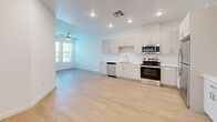 Located at 6540 W Arby Ave in Las Vegas, NV, this 2-bedroom, 1-bathroom unit offers a thoughtfully designed open-concept layout that maximizes its single-floor footprint. Light wood-tone flooring runs seamlessly throughout the entire space, lending warmth and visual continuity to every room.

The living and kitchen areas flow together in an expansive open plan, illuminated by recessed lighting and a ceiling fan. The kitchen is well-appointed with white shaker-style cabinetry extending to the ceiling for ample storage, bright white countertops, and a full suite of stainless steel appliances including a refrigerator, range, microwave, and dishwasher.

Both bedrooms are bright and clean, featuring white walls, light flooring, and windows fitted with blinds that allow natural light while maintaining privacy. The primary bedroom includes a ceiling fan and dual windows with outdoor views. The bathroom is finished in a crisp, modern style with a long dual-sink vanity topped in white, generous cabinet storage, gold-tone hardware, and recessed lighting above a wide mirror. A dedicated closet provides additional storage. The overall ambiance is clean, contemporary, and move-in ready.