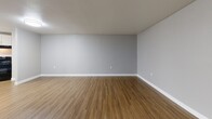 Located at 3506 Silver Park Dr in Suitland, MD, this 2-bedroom, 1-bathroom unit offers a well-organized single-floor layout designed for comfortable everyday living. The open living room features warm wood-look vinyl flooring, neutral gray walls, and large vertical-blind-covered sliding doors that allow natural light to fill the space. The kitchen is thoughtfully appointed with white shaker-style cabinetry, granite countertops, a stainless steel sink, and black appliances including a gas range, dishwasher, and refrigerator. An in-unit washer is also conveniently located within the kitchen area. A connecting hallway leads to both bedrooms, each carpeted in a warm neutral tone. The spacious primary bedroom features dual sliding closets, providing ample storage, while the second bedroom includes a large window with views of surrounding greenery, bringing in natural light and outdoor scenery. The bathroom is elegantly finished with marble-look wall tile surrounding a full soaking tub, a dark wood vanity, granite countertop, and a framed mirror, creating a clean and refined aesthetic throughout. White trim and baseboards provide a cohesive finish across all rooms.