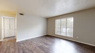 This one-bedroom, one-bathroom unit in Waco, Texas offers a thoughtfully organized single-floor layout that makes efficient use of its space. Dark hardwood-style flooring runs consistently throughout, lending warmth and visual cohesion to every room.

The living area is bright and open, anchored by a large window fitted with horizontal blinds that allow for natural light control and outdoor views. Neutral-toned walls and a textured ceiling complement the clean, understated aesthetic throughout.

The kitchen features a galley-style configuration with ample white cabinetry, dark countertops, and a stainless steel sink — providing generous storage and workspace. White appliances complete the functional setup.

The bedroom is a comfortable, well-proportioned retreat with the same hardwood-style flooring and soft neutral walls. A dedicated closet offers convenient built-in storage.

The bathroom is a standout feature, showcasing large-format marble-patterned tile extending from floor to ceiling in the tub and shower surround. A white vanity with cabinet storage, a mirror, and wood-look tile flooring round out the space with a refined, polished feel.

A private entry door with a six-panel design adds a welcoming touch to this clean, move-in-ready unit in Waco, TX.
