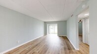 Located at 6742 Gulfport Blvd S in South Pasadena, FL, this updated 1-bedroom, 1-bathroom residence offers a thoughtfully designed single-floor layout with modern finishes throughout. Light wood-look flooring runs continuously through the space, creating a warm, cohesive feel.

The kitchen is a standout feature, showcasing taupe shaker-style cabinetry, crisp white quartz countertops, and a vibrant turquoise subway tile backsplash that adds a coastal flair. Stainless steel appliances — including a range, microwave, refrigerator, and dishwasher — are complemented by a built-in wine cooler, making this kitchen as functional as it is stylish. A peninsula counter connects the kitchen to the main living area, which is brightened by a ceiling fan and open sightlines.

The spacious primary bedroom offers ample room, soft sage-toned walls, natural light from a window with blinds, a ceiling fan, and access to a dedicated closet. The bathroom is cleanly appointed with white subway tile surrounding the tub/shower combo, accented by a decorative mosaic border, and features matching cabinetry consistent with the kitchen's design. The entrance provides a welcoming transition into the home. Overall, the space exudes a clean, coastal-modern ambiance ideal for comfortable Florida living.