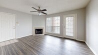 Located at 402 Galaxy Dr in Jackson, Tennessee, this single-story residence offers a well-organized layout designed for comfortable, functional living. The galley-style kitchen is efficiently arranged with warm wood cabinetry lining both sides, light countertops, wood-look plank flooring, a double-basin sink, electric range with overhead microwave, and a dishwasher, providing ample storage and workspace throughout.

The living area serves as a central gathering space, featuring rich hardwood-style flooring, a textured ceiling, and a ceiling fan with light fixture. A corner fireplace with a tile surround adds a notable focal point, while large windows and a glass-paned door invite natural light and views of the surrounding neighborhood. An adjacent dining or flex area with matching flooring offers additional versatility.

The bedrooms are carpeted and bathed in natural light from well-placed windows, each offering a quiet, comfortable atmosphere. The primary bedroom is notably spacious and includes a ceiling fan. The bathrooms feature tile flooring, a tub-shower combination, and wood-toned vanity cabinetry. A dedicated laundry room accommodates a full-sized washer and dryer with overhead shelving for added storage convenience.