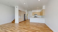 Located in Lancaster, CA, this well-appointed two-story home offers 2 bedrooms and 3 bathrooms across two thoughtfully designed floors. The main level features an open-concept kitchen and living area bathed in natural light from large sliding glass doors with vertical blinds. The kitchen is a standout, showcasing light wood flat-panel cabinetry, crisp white quartz countertops, a central island with an undermount sink, and a full suite of stainless steel appliances. Warm wood-look luxury vinyl plank flooring runs throughout, tying the spaces together cohesively. The living area offers generous proportions and direct outdoor access, creating a bright and airy atmosphere. Upstairs, the primary bedroom is a spacious retreat featuring large windows with outdoor views and a well-organized walk-in closet with built-in shelving and dual hanging rods. The additional bedroom is equally bright, with wide windows that invite natural light. All three bathrooms are finished in a clean, modern aesthetic with tub-shower combos featuring brushed nickel fixtures, white subway tile surrounds, and light wood vanities with white countertops. Clean white walls, recessed lighting, and consistent flooring throughout give the entire home a fresh, contemporary feel.