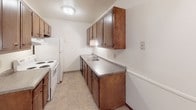 Located at 400 S Sneve Ave in Sioux Falls, South Dakota, this single-floor unit offers a practical and comfortable layout designed for everyday living. The spacious living area features wall-to-wall carpeting, a textured ceiling, and a sliding glass door fitted with vertical blinds that opens to a private balcony, filling the room with natural light and offering outdoor views. A wall-mounted air conditioning unit provides additional climate control in the living space, which also features baseboard heating throughout.

The kitchen is equipped with rich, dark wood cabinetry offering ample upper and lower storage, a double-basin sink, laminate countertops, and white appliances including a range and refrigerator, all set on easy-to-clean tile flooring.

The bedrooms are generously sized, each featuring plush carpeting, ceiling fans with integrated lighting, baseboard heating, and windows with blinds that allow for natural light. One bedroom includes a sliding closet, providing convenient storage.

The bathroom is clean and functional, featuring a full tub-and-shower combination with a curtain rod, tile flooring, and a wood-paneled door. The entry area provides a welcoming transition into the unit, with a sliding storage panel nearby adding organizational convenience throughout the home.