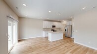 Located at 4215 N McCord Rd in Sylvania, Ohio, this two-story home offers a thoughtfully designed layout spread across two floors. The main level features an open-concept kitchen and living area finished with light hardwood flooring and recessed lighting throughout. The kitchen is outfitted with crisp white shaker cabinetry, a subway tile backsplash, light stone countertops, a center island with a sink, and stainless steel appliances including a range, over-the-range microwave, and refrigerator. A charming rustic barn door adds character to the main floor hallway, which also connects to a neatly appointed half bathroom with warm gold fixtures and a white vanity. The attached garage provides ample parking and storage space with an automatic opener. Upstairs, the home hosts three bedrooms, each with plush carpeting and ceiling fans. The spacious primary bedroom includes a large walk-in closet with wire shelving on multiple walls. A dedicated laundry room on the upper level features side-by-side washer and dryer units beneath built-in white cabinetry. With four full bathrooms, four closets, and a neutral color palette throughout, this home delivers a clean, modern aesthetic with practical, well-organized living spaces.