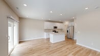 Located at 4215 N McCord Rd in Sylvania, Ohio, this two-story home offers a thoughtfully designed layout spread across two floors. The main level features an open-concept kitchen and living area finished with light hardwood flooring and recessed lighting throughout. The kitchen is outfitted with crisp white shaker cabinetry, a subway tile backsplash, light stone countertops, a center island with a sink, and stainless steel appliances including a range, over-the-range microwave, and refrigerator. A charming rustic barn door adds character to the main floor hallway, which also connects to a neatly appointed half bathroom with warm gold fixtures and a white vanity. The attached garage provides ample parking and storage space with an automatic opener. Upstairs, the home hosts three bedrooms, each with plush carpeting and ceiling fans. The spacious primary bedroom includes a large walk-in closet with wire shelving on multiple walls. A dedicated laundry room on the upper level features side-by-side washer and dryer units beneath built-in white cabinetry. With four full bathrooms, four closets, and a neutral color palette throughout, this home delivers a clean, modern aesthetic with practical, well-organized living spaces.