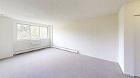 Located at 352 Newfield St in Middletown, Connecticut, this three-bedroom, one-bathroom unit offers a practical and well-organized single-floor layout. The spacious primary bedroom features large windows that invite natural light and offer views of surrounding greenery, complemented by soft carpeting and baseboard heating throughout. The additional bedrooms are similarly carpeted and bright, each equipped with generous closet space, including built-in folding-door closets, and windows fitted with blinds for privacy. A hallway connects the rooms efficiently, with a dedicated closet providing extra storage. The kitchen is outfitted with warm honey-toned wood cabinetry, granite-patterned countertops, a stainless steel sink, a gas range, and a full-size refrigerator, all set on easy-care tile flooring. The bathroom features a full tub-shower combination with white tile surround and accessible grab bars for added safety and convenience. Baseboard heating is present throughout the unit, ensuring consistent warmth. The clean, neutral palette of white walls and light carpeting creates a bright, cohesive atmosphere across the entire space, making it a straightforward and functional home.