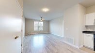 Located in Greeley, Colorado, this single-story home offers a clean, contemporary design with a practical and efficient layout. The living room is a welcoming space featuring light wood-style flooring, a ceiling fan, and a window that brings in natural light, creating a bright and airy atmosphere. A hallway connects the main areas, leading to the kitchen, which is equipped with white cabinetry, dark countertops, and a full suite of black appliances including a refrigerator, range, microwave, and dishwasher. The kitchen's light flooring contrasts attractively with the bold appliance finishes. The bedroom is a comfortable retreat with plush carpeting, a large window allowing ample natural light, and two closets providing generous storage. The home includes three bathrooms, each finished with light wood-style flooring, white vanity cabinetry, and dark countertops. One bathroom features a full soaking tub and shower combination. Additional spaces include a dedicated laundry room and a utility room, adding to the home's overall functionality. Neutral wall tones and consistent flooring throughout create a cohesive, modern aesthetic well-suited for comfortable everyday living.