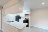 Located at 10101 W Sam Houston Parkway in Houston, TX, this one-bedroom, one-bathroom residence offers a well-utilized single-floor layout designed for comfortable everyday living. Light wood-style flooring flows consistently throughout the space, creating a clean and cohesive aesthetic.

The open-concept living, dining, and kitchen area serves as the heart of the home. The living room features a ceiling fan with light fixture and large sliding glass doors dressed with vertical blinds, allowing natural light to fill the space. A bold blue entry door adds a distinctive architectural accent. The kitchen is appointed with white cabinetry, marble-style countertops, a peninsula with additional prep space, a black refrigerator, and a black electric range — all complemented by a single-basin sink.

The spacious primary bedroom includes a ceiling fan, a natural light window with blinds, and access to two closets, providing ample storage. The bathroom offers a full tub-and-shower combination finished with white tile surround and brushed nickel fixtures. Additional functional spaces include a dedicated pantry and an in-unit laundry area, rounding out a practical and efficiently organized floor plan.