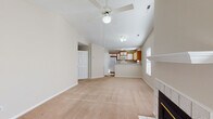 Located at 2707 Meridian Dr in Greenville, NC, this single-floor residence offers a well-designed, open layout that maximizes comfort and functionality. The living area is a standout space, featuring soaring vaulted ceilings, a ceiling fan, and a tile-surround fireplace that serves as a natural focal point. Plush carpeting runs throughout the main living and bedroom areas, lending a warm, comfortable feel. The kitchen is efficiently arranged with a peninsula breakfast bar that opens to the living space, warm wood-toned cabinetry with white panel accents, and white appliances including a range, built-in microwave, refrigerator, and dishwasher. Tile flooring anchors the kitchen and bathrooms. The primary bedroom impresses with its own vaulted ceiling, a large arched window that floods the room with natural light, a ceiling fan, and a spacious walk-in closet. Additional bedrooms are generously sized, each with ceiling fans and closet space. A secondary bedroom provides access to an outdoor patio through glass doors. The bathrooms are appointed with wood-toned vanities, wide mirrors, and tile flooring, with the primary bath featuring an extended vanity and separate soaking tub. A large walk-in closet and a dedicated laundry area with washer/dryer connections round out the practical storage offerings throughout this well-appointed home.