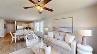 Located in Leland, NC, this two-story, 4-bedroom, 3-bathroom home offers a well-designed layout spread across two floors. The main level hosts an open-concept living, dining, and kitchen area filled with natural light from large windows. The kitchen is outfitted with granite countertops, white cabinetry, stainless steel appliances, and a central island with a double sink — ideal for both everyday cooking and entertaining. The adjoining dining area flows seamlessly into the living room, which features wood-look flooring, a ceiling fan, and a glass door leading to an outdoor patio with neighborhood views. A dedicated laundry room with full-size washer and dryer hookups and an attached garage add convenience on the main floor. Upstairs, four well-proportioned bedrooms offer carpeted floors and ample closet space. The primary bedroom provides a comfortable retreat, while the additional bedrooms are versatile enough for guests or a home office. The bathrooms are finished with granite vanity tops, white cabinetry, wood-look tile flooring, and glass-enclosed showers. With a clean, neutral palette and practical layout, this home delivers functional living in a welcoming setting.