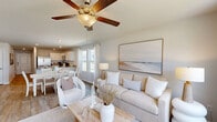 Located in Leland, NC, this two-story, 4-bedroom, 3-bathroom home offers a well-designed layout spread across two floors. The main level hosts an open-concept living, dining, and kitchen area filled with natural light from large windows. The kitchen is outfitted with granite countertops, white cabinetry, stainless steel appliances, and a central island with a double sink — ideal for both everyday cooking and entertaining. The adjoining dining area flows seamlessly into the living room, which features wood-look flooring, a ceiling fan, and a glass door leading to an outdoor patio with neighborhood views. A dedicated laundry room with full-size washer and dryer hookups and an attached garage add convenience on the main floor. Upstairs, four well-proportioned bedrooms offer carpeted floors and ample closet space. The primary bedroom provides a comfortable retreat, while the additional bedrooms are versatile enough for guests or a home office. The bathrooms are finished with granite vanity tops, white cabinetry, wood-look tile flooring, and glass-enclosed showers. With a clean, neutral palette and practical layout, this home delivers functional living in a welcoming setting.
