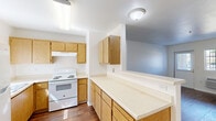 Located at 560 Adams Ave in Orange Cove, CA, this single-floor, one-bedroom, one-bathroom unit offers a practical and well-organized layout. Rich, dark hardwood-style flooring runs throughout the entire space, creating a warm and cohesive aesthetic against the clean white walls.

The kitchen is thoughtfully designed with an L-shaped layout, featuring warm oak cabinetry — both upper and lower — paired with light countertops that offer ample prep space. A white electric range with a ventilation hood, a double-basin sink beneath a window that invites natural light, and a full-size refrigerator complete the functional setup.

The living room is open and airy, with a wall-mounted HVAC unit, a front entry door, and a window fitted with vertical blinds that allow for adjustable light control. The space flows easily and provides a comfortable, versatile area for everyday living.

The bedroom mirrors the living room's clean design, with its own window, wall-unit HVAC, and access to closet storage. Three closets are distributed throughout the unit, providing generous storage options.

The bathroom includes a floating oak vanity with a single sink, a wall-mounted mirror, a shower with grab bars, and a window with vertical blinds for natural light. A private patio rounds out this well-appointed unit.