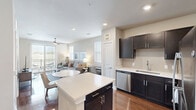 Located at 1501 Meridian Dr in Irving, TX, this one-bedroom, one-bathroom residence offers a thoughtfully designed layout with efficient use of space throughout. The open-concept kitchen and living area serves as the heart of the home, featuring rich hardwood-style flooring, dark espresso cabinetry, white quartz countertops, a central island, and a full suite of stainless steel appliances including a refrigerator, range, microwave, and dishwasher. Recessed lighting and a neutral color palette keep the space feeling bright and modern. The living room is filled with natural light from multiple windows and a sliding glass door that opens to a private balcony with outdoor views, while a ceiling fan adds year-round comfort. The bedroom offers plush carpeting, a ceiling fan, natural light from a window with blinds, and access to a well-organized walk-in closet complete with built-in shelving, hanging rods, and a central bench. The bathroom features dark cabinetry, a white countertop vanity, a large mirror, and polished hardwood-style flooring that connects seamlessly to the rest of the residence. Clean lines and a neutral palette create a cohesive, contemporary ambiance throughout.