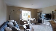 Located at 6400 Preserve Crossing Blvd N in Gahanna, Ohio, this three-story home offers a well-designed layout spread across multiple levels, providing ample space for comfortable living. The living area is a standout feature, characterized by warm neutral wall tones, plush carpeting, and an abundance of natural light streaming through large sliding glass doors and windows. These generous windows frame views of the surrounding community and a private balcony, seamlessly connecting the interior to the outdoors. The living room is thoughtfully laid out to accommodate both relaxed seating and functional entertaining, with room for a sofa, accent chairs, and decorative shelving. The open, airy feel of the space is enhanced by the soft, neutral color palette that runs throughout, creating a cohesive and inviting ambiance. With three floors of living space, this home offers versatility and room to grow, making it well-suited for a variety of lifestyles. The Preserve Crossing community in Gahanna provides a scenic backdrop, with mature trees and neighboring architecture visible from the interior windows, adding a sense of community and natural surroundings to everyday living.