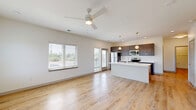 Located at 2136 Central Ave in Indianapolis, Indiana, this modern single-floor residence offers 2 bedrooms and 2 bathrooms within a thoughtfully designed open-concept layout. Light hardwood flooring flows seamlessly throughout the entire space, creating a cohesive and airy feel.

The combined kitchen and living area forms the heart of the home, flooded with natural light through large windows that offer outdoor views. A ceiling fan adds comfort to the spacious living area, which also features a sliding door for additional access and light. The contemporary kitchen is anchored by a large center island with a white quartz countertop and undermount sink, complemented by dark wood cabinetry, stainless steel appliances — including a refrigerator, electric range, and microwave — and globe pendant lighting overhead.

The primary bedroom is generously sized, featuring dual windows, a ceiling fan, and direct access to a private bathroom. The en-suite bath includes a dual-sink vanity with white countertops, dark wood cabinetry, and a walk-in closet with built-in shelving and hanging rods. The second bedroom is well-proportioned with clean white walls and hardwood flooring. Additional highlights include a dedicated laundry area, a utility room, and ample closet storage throughout.