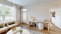 This 660-square-foot, one-bedroom, one-bathroom apartment at 2418 Main Street in Rocky Hill, CT is a well-appointed single-floor residence that blends contemporary design with artistic character. Warm-toned hardwood-style flooring flows throughout the unit, creating a cohesive aesthetic across every room. The open-concept living room is a standout, featuring a striking floor-to-ceiling abstract wall mural, a ceiling fan, and large windows with sheer curtains that invite abundant natural light and outdoor views. A dedicated workspace with a built-in desk adds functional versatility. The modern kitchen is equipped with stainless steel appliances, white upper cabinetry, a wood-paneled island with a white quartz countertop, an undermount sink, and pendant lighting, providing both style and practicality. The 130-square-foot primary bedroom includes a geometric accent wall mural, a ceiling fan, and a large window overlooking greenery. The bathroom features clean, neutral finishes and direct access to a dedicated walk-in closet with wire shelving and hanging rods. An in-unit stacked washer and dryer is also included. The unit's neutral color palette, artistic murals, and modern fixtures create a bright, sophisticated, and highly livable space.