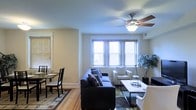 Located at 239 W Johnson Street in Philadelphia's Germantown neighborhood, this single-floor residence offers a well-organized and comfortable living environment. The open layout connects the living and dining areas seamlessly, creating a cohesive space that feels both functional and inviting.

The living area is highlighted by a ceiling fan with a built-in light fixture, providing both air circulation and ambient lighting. Multiple windows fitted with horizontal blinds allow generous natural light to fill the room while maintaining privacy. The hardwood flooring runs throughout, lending warmth and a classic aesthetic to the space.

The dining area, positioned adjacent to the living room, accommodates a full dining set and benefits from its own window, further enhancing the bright and airy character of the home. The neutral wall tones throughout complement the natural wood floors and contribute to a clean, understated palette that suits a variety of interior styles.

Overall, the space presents a practical single-level layout with thoughtful flow between living and dining zones, making it well-suited for everyday living in one of Philadelphia's established residential neighborhoods.