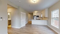 Located at 502 Howe Ave in Shelton, Connecticut, this well-appointed single-floor residence offers a clean, modern aesthetic throughout. The open-concept living and kitchen area serves as the heart of the home, featuring light-toned luxury vinyl plank flooring that extends seamlessly across the main living spaces. The kitchen is outfitted with crisp white shaker-style cabinetry, stone countertops with subtle speckled detailing, a classic subway tile backsplash, and a full suite of stainless steel appliances including a refrigerator, microwave, and dishwasher. A peninsula counter provides additional workspace and casual seating. Natural light filters into the living area through large windows, enhancing the bright, airy atmosphere. The bedrooms continue the light hardwood-style flooring and neutral wall tones, each with windows overlooking the surrounding neighborhood. Louvered closet doors add a functional, classic touch. The bathrooms are finished with elegant marble-style porcelain tile flooring and include full tub-shower combinations with curved curtain rods, vanities with under-cabinet storage, and clean white fixtures. The overall design of the space is cohesive and contemporary, with neutral tones and quality finishes throughout.