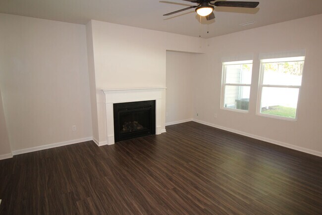Family room features gas log fireplace, large windows & luxury laminate flooring. - 3406 Dropseed Dr