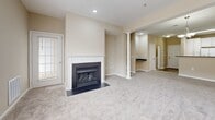 Located at 10090 Mill Run Cir in Owings Mills, MD, this well-appointed one-bedroom, one-bathroom residence offers a thoughtfully designed single-floor layout that makes excellent use of its space. Warm neutral tones and plush carpeting flow throughout, creating a cohesive and inviting ambiance.

The open-concept living room is a standout, anchored by a classic white-mantled fireplace and large windows that fill the room with natural light. A decorative column subtly defines the transition into the adjoining spaces, adding an architectural touch. The kitchen features white cabinetry, dark granite-style countertops, a breakfast bar peninsula, and built-in open shelving — ideal for both function and display. Wood-look flooring grounds the kitchen area.

The generously sized bedroom offers sliding glass door access to a private balcony, along with large windows that provide additional natural light and outdoor views. A spacious walk-in closet with wire shelving system provides ample storage.

The full bathroom is clean and bright, featuring a white vanity, a soaking tub with a glass shower screen, and wood-look flooring that complements the home's overall aesthetic. This residence combines practical design with comfortable living in a convenient Owings Mills location.