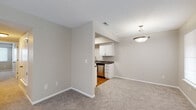 This single-floor residence offers a clean, functional layout designed for comfortable everyday living. The living area greets you upon entry, featuring soft carpeted flooring, neutral warm-toned walls, and multiple windows dressed with blinds that allow natural light to filter through. A pendant light fixture anchors the dining area, which opens directly into the kitchen.

The galley-style kitchen is efficiently designed with white shaker cabinetry, dark granite-style countertops, warm hardwood flooring, and a full suite of stainless steel appliances, including a refrigerator, range, microwave, and dishwasher. A stainless steel sink with a modern faucet completes the workspace.

The two bedrooms are carpeted and finished in the same neutral tones found throughout the home, each featuring windows with blinds that bring in natural light and create a calm, restful atmosphere.

Both bathrooms are appointed with white vanity cabinetry, dark countertops, full-size tub-shower combinations with chrome fixtures, and large mirrors. One bathroom features hardwood-style flooring, while the other is finished with a coordinating design. A textured ceiling is consistent throughout the space, adding a subtle architectural detail. Overall, the residence presents a cohesive, move-in-ready environment with practical finishes at every turn.