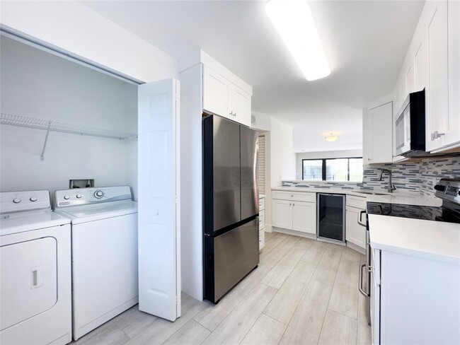 In-unit laundry with a side by side washer and dryer pair. - 2029 N Ocean Blvd