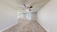 This 2-bedroom, 1-bathroom unit in El Cajon, California offers a well-organized single-level layout designed for comfortable everyday living. The galley-style kitchen is a standout feature, lined with crisp white cabinetry on both sides, light wood-look vinyl flooring, a stainless steel refrigerator, and an electric range — providing ample counter and storage space in a clean, efficient configuration.

The living area is carpeted and features a ceiling fan with light fixture, a textured ceiling, and a wall-mounted HVAC unit, keeping the space comfortable year-round. Natural light filters in through blinded windows, creating a bright and welcoming atmosphere.

The primary bedroom is generously sized, offering plush carpeting, a ceiling fan, a window with exterior views, and a sliding-door closet with built-in shelving for organized storage. The additional bedrooms are similarly appointed with carpet, ceiling fans, and windows that bring in natural light.

Throughout the unit, neutral warm-gray tones on the walls complement the light carpeting and white trim, giving the space a clean, move-in-ready feel. The consistent use of ceiling fans, textured ceilings, and blinded windows across all rooms adds to the cohesive and practical character of this El Cajon residence.