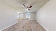 This 2-bedroom, 1-bathroom unit in El Cajon, California offers a well-organized single-level layout designed for comfortable everyday living. The galley-style kitchen is a standout feature, lined with crisp white cabinetry on both sides, light wood-look vinyl flooring, a stainless steel refrigerator, and an electric range — providing ample counter and storage space in a clean, efficient configuration.

The living area is carpeted and features a ceiling fan with light fixture, a textured ceiling, and a wall-mounted HVAC unit, keeping the space comfortable year-round. Natural light filters in through blinded windows, creating a bright and welcoming atmosphere.

The primary bedroom is generously sized, offering plush carpeting, a ceiling fan, a window with exterior views, and a sliding-door closet with built-in shelving for organized storage. The additional bedrooms are similarly appointed with carpet, ceiling fans, and windows that bring in natural light.

Throughout the unit, neutral warm-gray tones on the walls complement the light carpeting and white trim, giving the space a clean, move-in-ready feel. The consistent use of ceiling fans, textured ceilings, and blinded windows across all rooms adds to the cohesive and practical character of this El Cajon residence.
