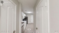 Located at 1400 E Cornwallis Rd in Durham, NC, this single-floor, 2-bedroom, 1-bathroom residence offers a clean, modern design with a neutral color palette throughout. The kitchen is a functional highlight, featuring white cabinetry, light quartz-style countertops, and a full suite of stainless steel appliances including a refrigerator, electric range, microwave, and dishwasher. Light wood-style flooring runs through the main living areas, complementing the bright, airy atmosphere. The open layout connects the kitchen seamlessly to the living area, which benefits from large windows offering views of surrounding greenery. Both bedrooms are generously sized, with soft carpeting, ceiling fans with integrated lighting, and windows that invite natural light and tree-lined views. The spacious primary bedroom provides ample room for a full furniture arrangement. The shared bathroom is well-appointed with a white vanity, under-sink storage, a large mirror, and a lighted fixture above. A dedicated closet provides additional storage. Textured ceilings and clean white trim are consistent throughout, giving the space a polished, well-maintained feel. The overall ambiance is bright, neutral, and move-in ready.