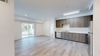 Located at 3057 W Pico Blvd in Los Angeles, this well-designed 3-bedroom, 2-bathroom unit offers a clean, modern aesthetic throughout. Light wood-tone flooring flows seamlessly across every room, creating a bright and cohesive feel. The open kitchen and living area forms the heart of the unit, featuring contemporary wood-grain cabinetry, white countertops, and a full suite of stainless steel appliances including a gas range, microwave, refrigerator, and dishwasher. Recessed lighting and direct sightlines to the adjoining living area make the space feel open and functional. The living room is bathed in natural light and opens through sliding glass doors onto a private balcony with views of mature palm trees. Three well-proportioned bedrooms offer clean white walls and generous natural light, including one bedroom with a tall narrow window that frames an outdoor view. The spacious primary bedroom provides a comfortable retreat. Two bathrooms serve the unit — one featuring a full tub-shower combination with built-in shelving, and another paired conveniently with the in-unit laundry area, which includes a stacked washer and dryer behind louvered doors. A hallway connects all rooms efficiently, completing this thoughtfully laid-out Los Angeles residence.