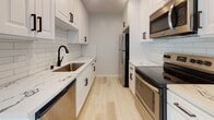Located in the desirable West Los Angeles neighborhood of Brentwood, this thoughtfully renovated single-floor residence at 1231 S Bundy Dr offers a clean, modern aesthetic throughout. Light-toned hardwood flooring flows seamlessly across the open living areas, complementing the neutral palette of the walls and textured ceilings. The spacious living room is bathed in natural light from sliding glass doors that open to a private balcony, and is equipped with a ceiling fan and wall-mounted AC unit for year-round comfort. A stylish barn door adds a contemporary design touch, providing access to the in-unit laundry closet, which houses a stacked Bosch washer and dryer.

The galley-style kitchen is well-appointed with white shaker cabinetry, matte black hardware, quartz countertops, a subway tile backsplash, a black undermount sink, and a full suite of stainless steel appliances. The bedrooms are generously sized, each featuring mirrored sliding closet doors and wall AC units, with ample natural light from windows with blinds. Two bathrooms serve the unit: one featuring a subway-tiled tub/shower combo with a glass enclosure, and another with a walk-in glass shower and mosaic tile flooring, both finished with clean white fixtures and modern hardware.