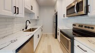 Located in the desirable West Los Angeles neighborhood of Brentwood, this thoughtfully renovated single-floor residence at 1231 S Bundy Dr offers a clean, modern aesthetic throughout. Light-toned hardwood flooring flows seamlessly across the open living areas, complementing the neutral palette of the walls and textured ceilings. The spacious living room is bathed in natural light from sliding glass doors that open to a private balcony, and is equipped with a ceiling fan and wall-mounted AC unit for year-round comfort. A stylish barn door adds a contemporary design touch, providing access to the in-unit laundry closet, which houses a stacked Bosch washer and dryer.

The galley-style kitchen is well-appointed with white shaker cabinetry, matte black hardware, quartz countertops, a subway tile backsplash, a black undermount sink, and a full suite of stainless steel appliances. The bedrooms are generously sized, each featuring mirrored sliding closet doors and wall AC units, with ample natural light from windows with blinds. Two bathrooms serve the unit: one featuring a subway-tiled tub/shower combo with a glass enclosure, and another with a walk-in glass shower and mosaic tile flooring, both finished with clean white fixtures and modern hardware.