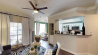 This single-story, one-bedroom, one-bathroom unit is thoughtfully designed with a cohesive open layout that connects the living, dining, and kitchen areas seamlessly. The living room features crown molding, a ceiling fan, and hardwood-style flooring, complemented by bold green accent walls that add a vibrant contrast to the neutral palette throughout. Large windows allow ample natural light to fill the space, enhancing the open feel.

The kitchen is well-appointed with white shaker-style cabinetry, granite-look countertops, a subway tile backsplash, and a full suite of stainless steel appliances, including a refrigerator, dishwasher, microwave, and range. A pass-through counter connects the kitchen to the living and dining areas, making the layout practical for everyday living.

The bedroom is spacious, featuring a ceiling fan with crown molding, a bold green accent wall, plush carpeting, and private patio access via French doors. A walk-in closet provides generous storage. The bathroom includes a tub-shower combination, white vanity cabinetry, and granite-look countertops. Additional highlights include an in-unit washer and dryer and a dedicated storage area with built-in wire shelving.