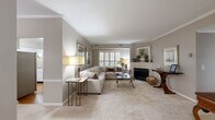 Located in Owings Mills, MD, this well-appointed single-floor home offers 1 bedroom, 2 bathrooms, and a spacious, comfortable layout finished with neutral tones and elegant crown molding throughout. The inviting living room features plush carpeting, plantation shutters that filter natural light, a wood-burning fireplace flanked by a decorative mantle, and ample space for relaxed entertaining. Adjacent to the living area, a refined dining room accommodates a full dining set beneath a pendant light fixture, complemented by chair-rail molding that adds architectural character. The kitchen is equipped with white cabinetry, stainless steel appliances, hardwood flooring, and a breakfast bar that connects seamlessly to the living area. The generously sized primary bedroom offers a serene retreat with plush carpeting, plantation shutters, crown molding, and a dedicated sitting area with outdoor views. The en-suite bathroom features white tile flooring, a vanity with ample counter space, and a glass-enclosed shower. A second full bathroom and a dedicated laundry room with side-by-side washer and dryer round out the functional layout. Three closets provide excellent storage throughout the home.