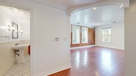 Located in the heart of West Hollywood on N Flores St, this well-appointed one-bedroom, one-bathroom residence masterfully blends classic architectural character with modern finishes. Rich hardwood flooring flows throughout the entire space, complementing the striking exposed brick walls that serve as a defining design element across the living and kitchen areas.

The open-concept living room and kitchen area is bright and welcoming, with multiple large windows that invite abundant natural light and offer lush, tree-lined views. Crown molding and a graceful archway add refined architectural detail to the living space. The kitchen is well-equipped with deep cherry wood cabinetry, granite countertops, a tile backsplash, stainless steel appliances including a gas range and refrigerator, and a custom range hood — all centered around a functional peninsula that opens to the living area.

The spacious bedroom features hardwood floors, a generous closet with built-in shelving, and large windows with sweeping views of the West Hollywood skyline and surrounding hills. The bathroom is elegantly appointed with classic black-and-white penny tile flooring, subway tile wainscoting, a pedestal sink, wall sconces, and a soaking tub — a timeless and polished retreat. A hallway connects the rooms with ease, completing this thoughtfully designed single-floor residence.