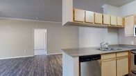Located at 2155 E Liberty Ln in Phoenix, AZ, this single-story, 3-bedroom, 2-bathroom home offers a well-designed layout across a comfortable footprint. The open kitchen and living area form the heart of the home, where dark wood-style flooring flows throughout. The kitchen is equipped with stainless steel appliances—including a range, microwave, and dishwasher—complemented by light maple cabinetry, a double-basin sink, and a peninsula with additional counter space. Crown molding accents the living area, which features recessed lighting and opens to a private patio through a sliding glass door, bringing in natural light and outdoor views. The primary bedroom is a well-proportioned retreat with a ceiling fan and direct patio access. The two additional bedrooms are carpeted, each featuring vertical blinds and windows that invite natural light. Both bathrooms are finished consistently, with wood-style flooring, white cabinetry with stone-tone countertops, and a tub-shower combination. A dedicated in-unit laundry area houses a full-size washer and dryer. With its functional layout, modern finishes, and convenient Phoenix location, this home offers comfortable single-story living.