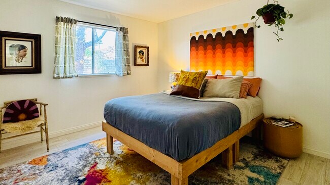 Furnished room with ultra comfortable queen bed, full closet, nightstand, tv, and chair - 64935 Leonard Ct