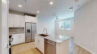 Located at 1820 Brittmoore Rd in Houston, TX, this thoughtfully designed one-bedroom, one-bathroom unit offers a clean, modern aesthetic across a single floor. The open-concept kitchen and living area serves as the heart of the home, anchored by a central island with a granite countertop and undermount sink. The kitchen is equipped with a full suite of stainless steel appliances, including a side-by-side refrigerator with ice and water dispenser, electric range, built-in microwave, and dishwasher. White shaker-style cabinetry, a subway tile backsplash, and recessed lighting complete the polished look. Light wood-look flooring flows seamlessly throughout the entire unit, enhancing the bright, airy feel. The living area features a ceiling fan and natural light from a window with blinds. The bedroom is a comfortable, well-proportioned space with its own ceiling fan, a window overlooking the outdoors, and direct access to a spacious walk-in closet outfitted with wire shelving on multiple walls. The bathroom features a granite-topped vanity with white cabinetry, a large mirror, and a tub-shower combination with marble-style tile surround. The unit presents a cohesive, contemporary design with neutral tones throughout.