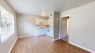 Located at 824 Arkansas St in Tallahassee, FL, this one-bedroom, one-bathroom unit offers a practical and well-organized single-floor layout. The combined kitchen and living area forms the heart of the home, where wood-style flooring runs throughout, creating a warm and cohesive feel. The kitchen is equipped with white cabinetry, granite-style countertops, a double-basin sink, and white appliances including an electric range and full-size refrigerator, making efficient use of the available space. Adjacent to the kitchen, the open living area provides a clean, neutral canvas with soft wall tones and ample room for everyday living. The bedroom is a comfortable retreat featuring plush carpeting, a ceiling fan with light fixture, and a window that invites natural light and outdoor views of surrounding greenery. A dedicated closet provides convenient storage. The bathroom is well-appointed with a dark wood vanity, granite-style countertop, and a full tub-shower combination with tiled surround. Wood-style flooring continues into the bathroom, tying the space together cohesively. Neutral gray walls and white trim throughout lend the unit a clean, move-in-ready appearance.