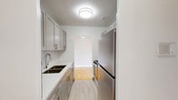 Located at 3125 Lawrence Ave E in Toronto's Scarborough neighbourhood, this one-bedroom, one-bathroom unit offers a practical and well-organized single-floor layout. Throughout the living areas and bedroom, warm-toned parquet flooring adds classic character, while neutral grey walls and white baseboards create a clean, bright atmosphere. The spacious living room is a standout feature, offering generous open space, a radiator heating unit, and access to a balcony with outdoor views — allowing natural light to fill the room. The bedroom is a comfortable size, featuring its own radiator, a window overlooking greenery, and the same parquet flooring that runs throughout the unit. The kitchen has been thoughtfully updated with light grey shaker-style cabinetry, white quartz countertops, a white subway tile backsplash, and a stainless steel electric range — combining modern aesthetics with functional design. The bathroom is finished with a full soaker tub and shower, surrounded by large-format marble-effect wall tiles in crisp white tones, giving the space a clean and polished look. A hallway connects all rooms efficiently, completing this well-appointed unit ideal for comfortable urban living.
