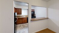 Located at 4608 Haverford Pl in Wilmington, Delaware, this single-floor, three-bedroom, one-bathroom residence offers a practical and comfortable layout. The living area features neutral-toned wall-to-wall carpeting, a window unit for climate control, and a baseboard heating system, creating a cozy atmosphere throughout. A pass-through counter connects the living space to the kitchen, which is equipped with warm wood cabinetry, granite-style countertops, a black appliance suite including a range, microwave, and refrigerator, and a mosaic tile backsplash accenting the cooking area. Tile flooring completes the kitchen's functional design. The spacious primary bedroom benefits from multiple windows that invite natural light and includes its own wall-mounted air conditioning unit. The two additional bedrooms are similarly carpeted and offer ample space, with one featuring a double-door closet. A hallway connects the bedrooms and leads to the full bathroom, which is a standout feature with its elegant marble-patterned surround encasing a full soaking tub and shower combination with polished chrome fixtures. A dedicated closet provides additional storage throughout this efficiently designed home.