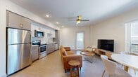 Located in Los Angeles' vibrant Arts District, this well-appointed one-bedroom, one-bathroom unit offers a thoughtfully designed open-concept layout. The combined kitchen and living area forms the heart of the home, featuring light hardwood-style flooring, crisp white walls, and a ceiling fan that enhances the bright, airy atmosphere. Large windows and a sliding glass door allow generous natural light to pour in while offering views of the surrounding cityscape.

The kitchen is equipped with stainless steel appliances — including a range, microwave, and dishwasher — complemented by two-tone gray and white cabinetry, a geometric tile backsplash, and a clean countertop workspace. The living area flows seamlessly into a dedicated dining space near the sliding door, creating an inviting area for both relaxing and entertaining.

The bedroom is a comfortable retreat, finished with plush carpeting, a ceiling fan, and a sizable window dressed with blinds for privacy. An adjacent walk-in closet provides ample storage with wire shelving and hanging rods. The bathroom features a full soaking tub and shower combination with classic white subway tile, tile flooring, and overhead cabinetry. In-unit laundry adds everyday convenience to this functional and modern urban residence.