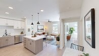 This well-designed 2-bedroom, 2-bathroom residence offers a thoughtfully planned open-concept layout that maximizes its comfortable footprint. Light hardwood-style flooring flows throughout, tying the living spaces together seamlessly.

The kitchen is a standout feature, equipped with stainless steel appliances including a refrigerator, range, microwave, and dishwasher. Two-tone cabinetry pairs white upper cabinets with warm wood-finish lower cabinets, accented by a classic white subway tile backsplash and a sleek quartz countertop. A central island with bar seating and dual matte black pendant lights adds both function and style.

The open living and dining area benefits from abundant natural light through large windows, a ceiling fan, and a wall-mounted mini-split system. The space connects naturally to the kitchen, making it ideal for everyday living and entertaining.

The primary bedroom is generously sized, featuring large windows with outdoor views that bring in ample natural light. Both bathrooms are finished in a clean, modern aesthetic with white tile surround tub-shower combinations and matte black fixtures.

The second bedroom also features bright windows with neighborhood views, completing this well-appointed, contemporary residence.