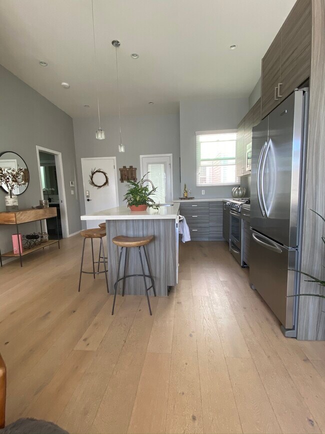 Open Kitchen with seating for four around bar. - 180 Dolores St