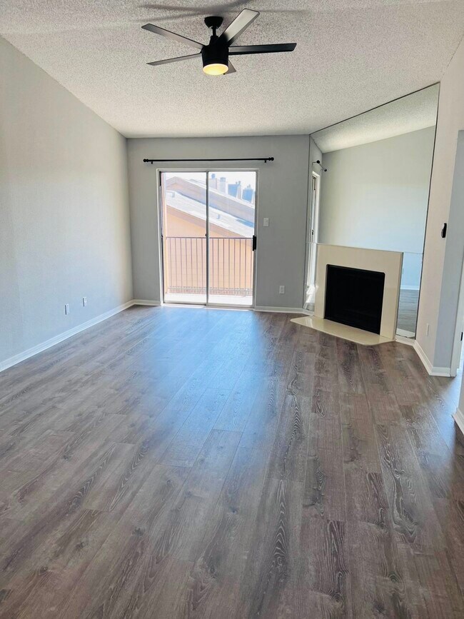 Sala de estar con chimenea que da a un balcón privado. - 2121 Hepburn St