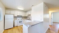 Located at 253 E Taylor St in Reno, Nevada, this 2-bedroom, 1-bathroom unit offers a well-organized single-floor layout with a cohesive, modern aesthetic. Light wood laminate flooring runs throughout the entire space, creating a bright and consistent look from room to room.

The combined kitchen and living area serves as the heart of the unit. The kitchen features white cabinetry, granite-style countertops, a classic subway tile backsplash, and white appliances including a refrigerator, electric range, and under-cabinet range hood. A stainless steel sink sits beneath a well-lit workspace, making the kitchen both functional and visually clean.

The living area provides a comfortable open space with a window unit for climate control and natural light from a front-facing window. Both bedrooms are bright and simply designed, with white walls, textured ceilings, and windows that bring in natural light with views of the surrounding neighborhood. The primary bedroom offers a sliding-door closet for storage. The second bedroom is equally well-lit and versatile.

The bathroom is finished with warm earth-toned tile surrounding a tub-shower combo with sliding glass doors, complemented by a dark wood vanity and light wood flooring, offering a practical yet stylish design.